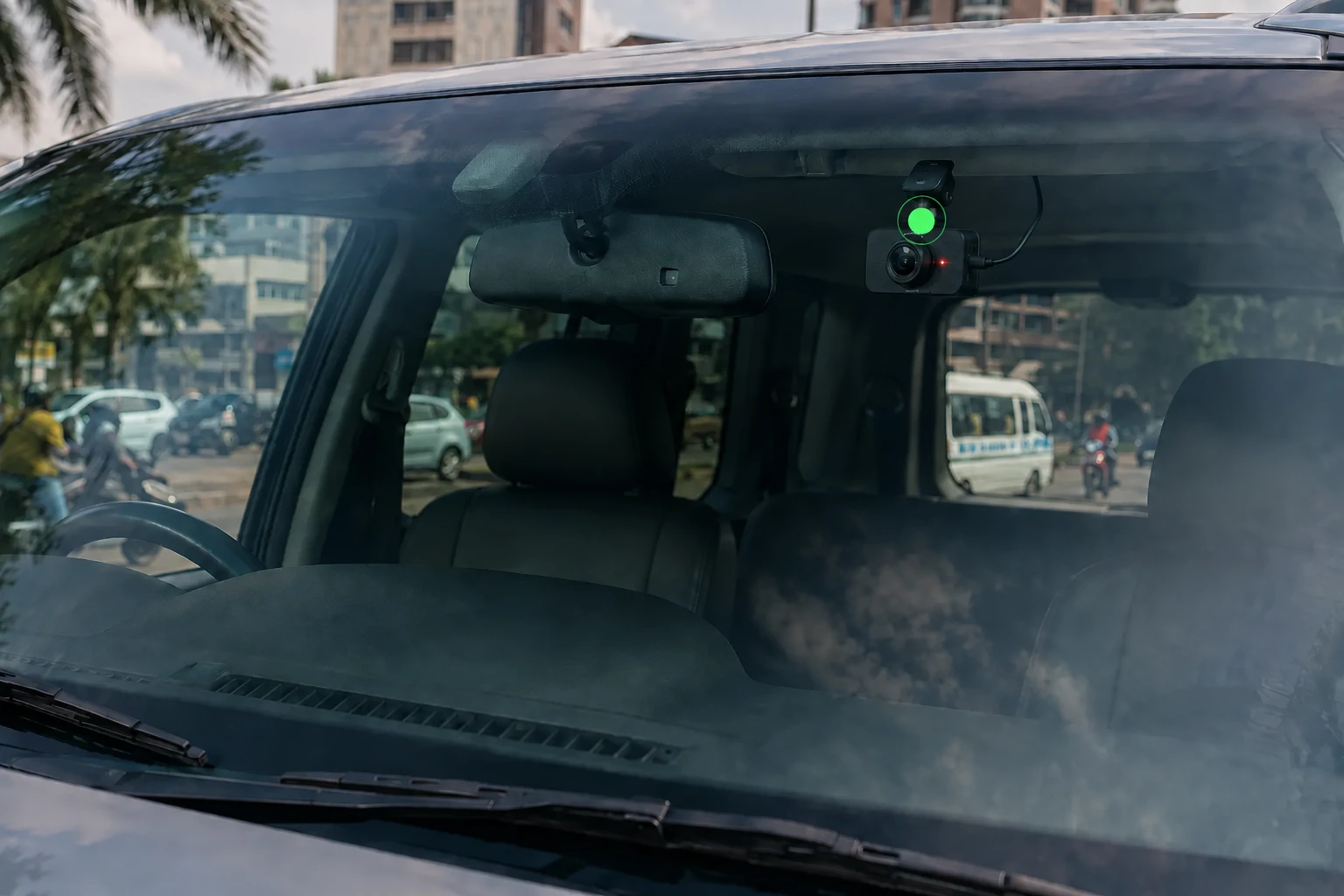 Road-facing dash camera mounted inside the windscreen with its lens recording traffic ahead